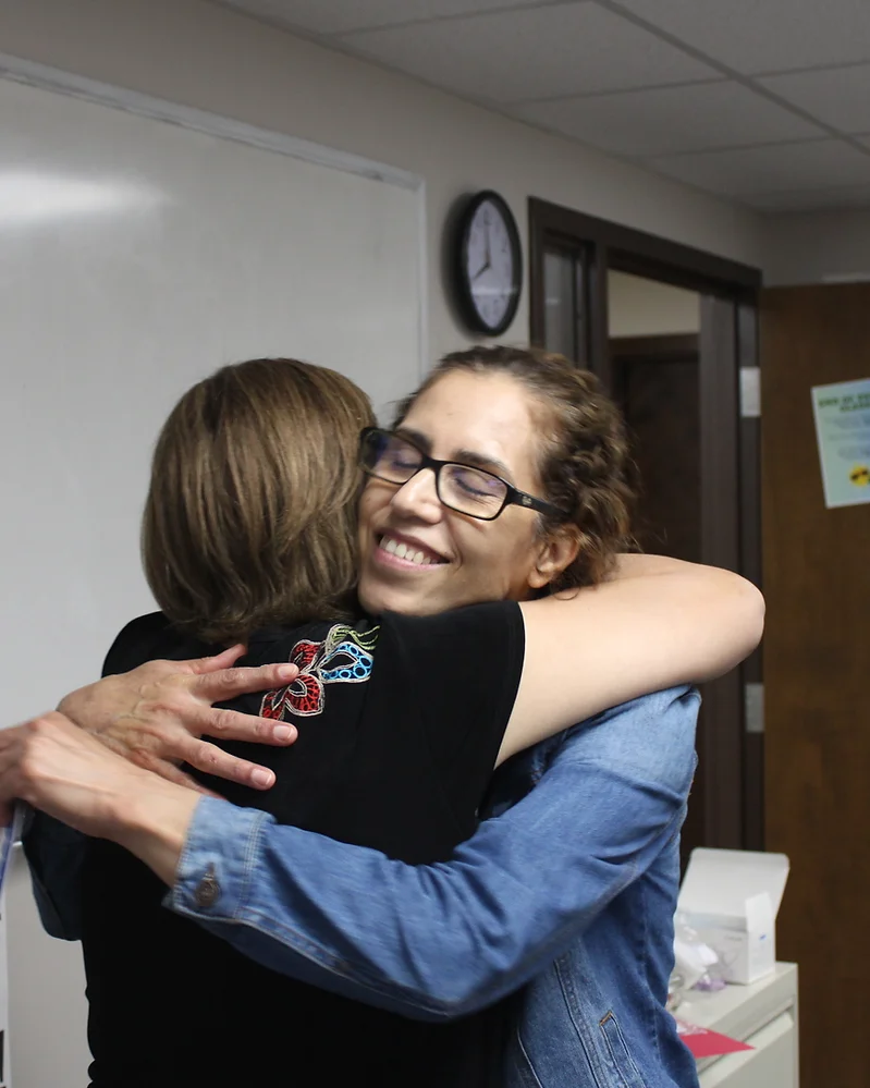 student hugging an adult